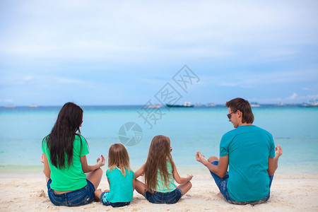 坐在沙滩莲花位置的四口人图片