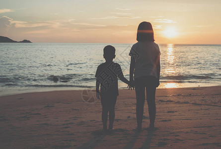 日落近岸边海滨的男女小男孩和女图片