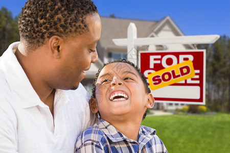 快乐的混合种族父子在出售的房地产标图片