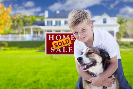 快乐的小男孩和他的狗在出售房地产图片