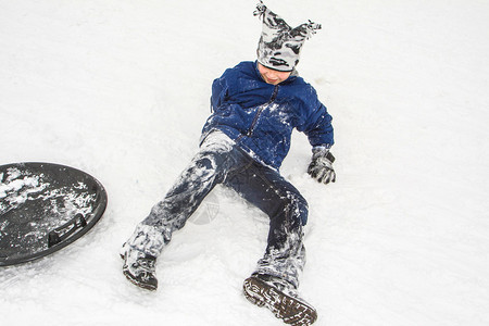 男孩享受冷雪滑下山图片