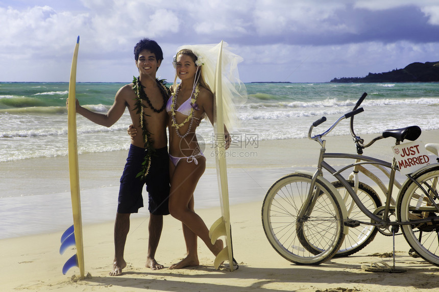 新婚夫妇在哈瓦伊海滩的海滩上带冲图片