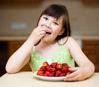 快乐的小女孩吃草莓图片