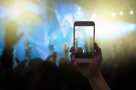 女手持智能手机拍摄视频录制或现场音乐会人群图片