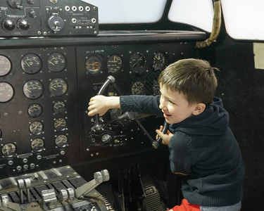小男孩在固定飞机里玩得开心驾驶图片