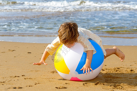 在海滩上玩充气球的微笑着图片
