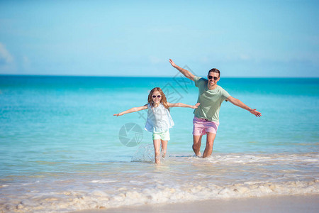 快乐的父亲和他可爱的女儿在热带海图片
