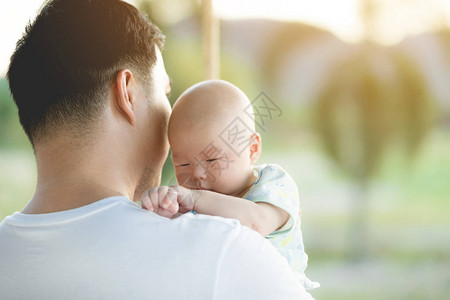 婴儿由父亲抱着父亲总是抱着他因为图片