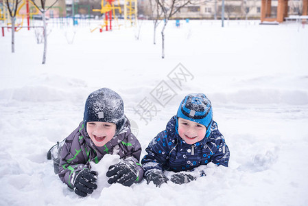 两个男孩在雪地里趴着开心的笑图片