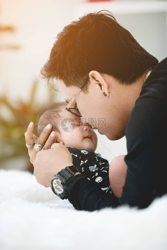 婴儿由父亲抱着父亲总是抱着他因为图片