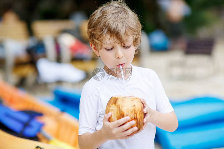 快乐有趣的学龄前小男孩在海滩上喝椰子汁孩子在热带岛屿上玩家庭度假夏天图片