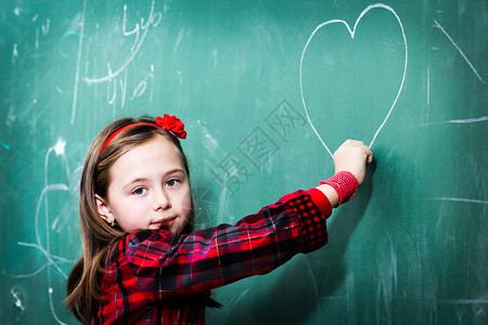 漂亮的小女孩在黑板上画心图片