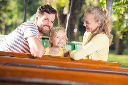 一个快乐的年轻家庭在公园前头露面笑着图片