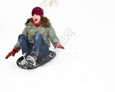 冬天在雪地上拉雪橇下山的女孩图片