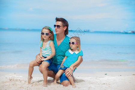 在海边父亲搂着两个女儿图片