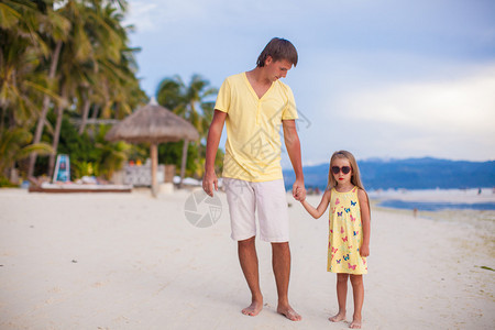 和他可爱的女儿一起快乐的父亲在热带海滩度假时走图片