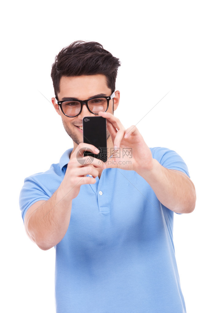 年轻笑着的闲人用手机照你的照片在白色背图片