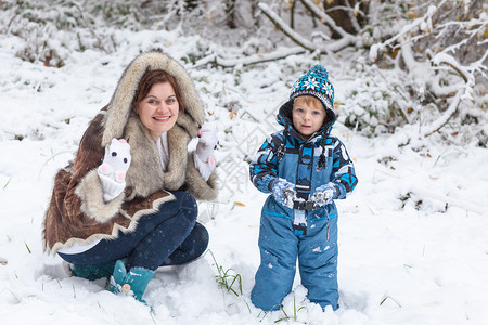 年轻母亲和小孩男在美丽的冬日与户外图片