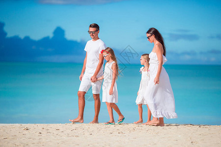 白沙滩上快乐的美丽家庭在卡比巴度图片