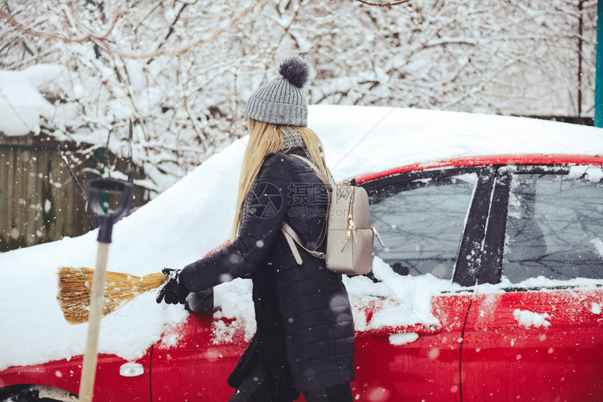 美丽金发女模特儿欢笑并愉快地扫雪图片