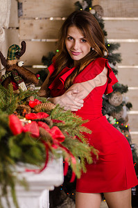 圣诞室内的美丽女人在圣诞树的下庆祝快乐图片