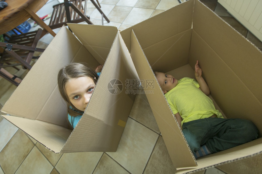 孩子们坐在纸板箱里拆箱搬进新图片