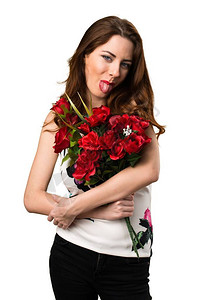 美丽的年轻女孩拿着鲜花吐出她的舌头图片