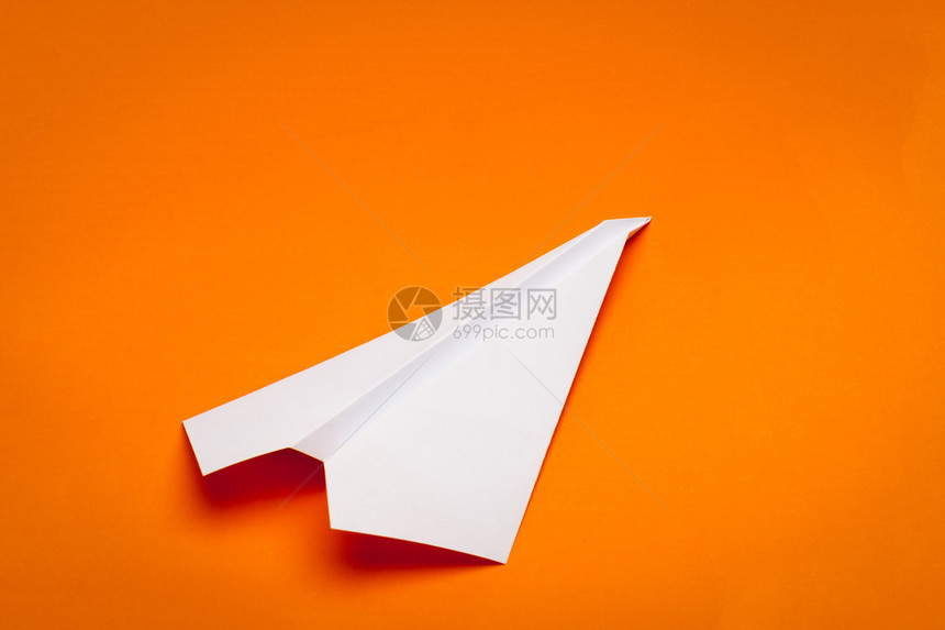 黄纸背景上的白纸飞机图片