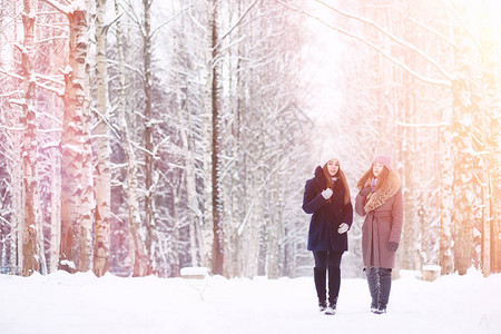 一个年轻的女孩在冬季公园散步冬季森林的圣诞假期女孩在公图片