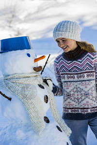 与雪人一起在瑞士山丘下雪的冬季村落中度过快图片