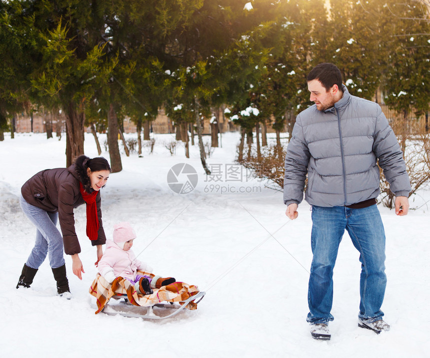 冬天公园的年轻幸福家庭孩子在雪图片