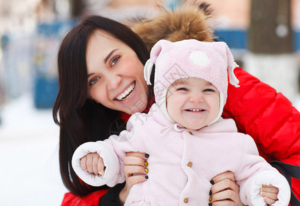 年轻的黑发母亲和她的女儿在户外冬天图片
