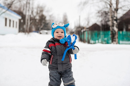 冬天在街上玩雪球的快乐小男孩图片