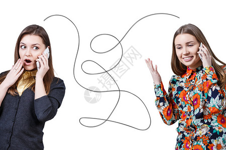 两个年轻漂亮的女孩通过手机相互交谈图片
