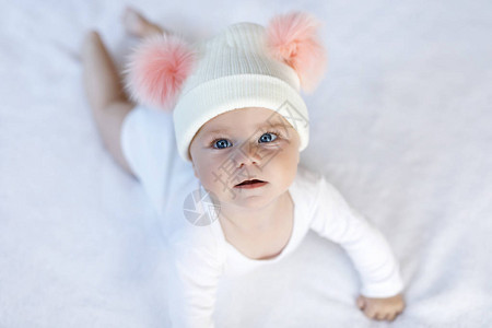 可爱的可爱宝贝孩子带着温暖的白色和粉红色帽子图片