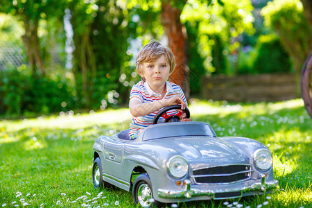 学龄前小男孩开着大玩具旧老爷车图片