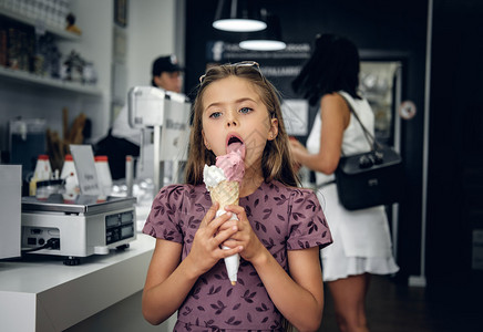 在咖啡馆吃冰淇淋的年轻漂亮女孩图片