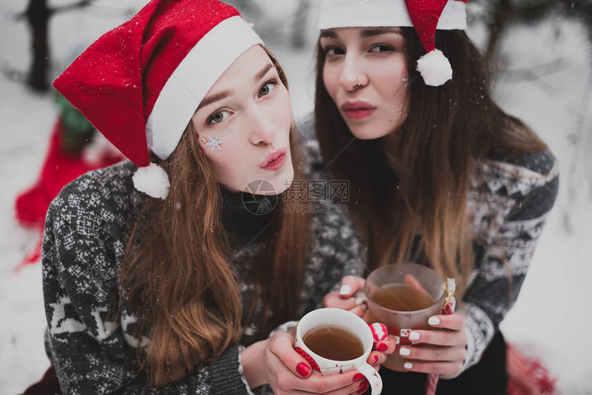 下雪天在户外戴圣诞帽拍照的女孩们图片
