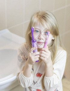 用电动牙刷刷牙的女孩图片