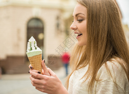 在街上吃美味冰淇淋的年轻美女图片