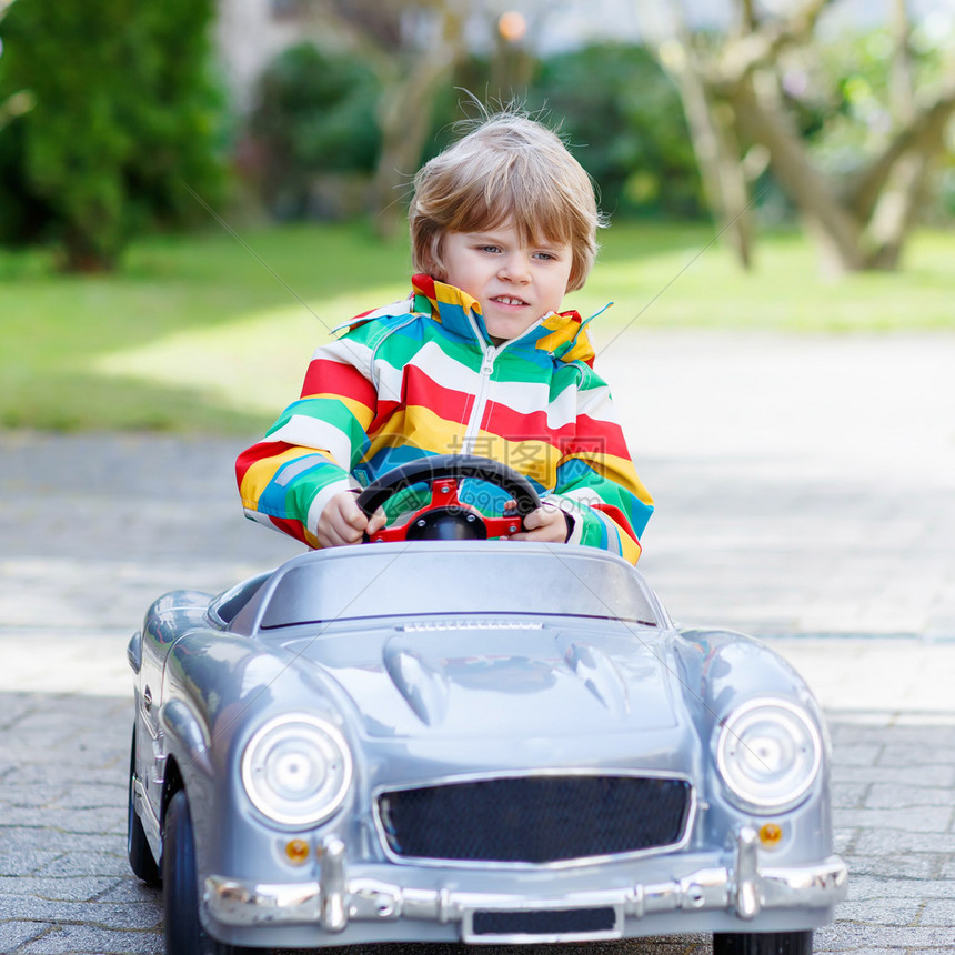 岁的孩子驾驶大型玩具旧老式汽车图片