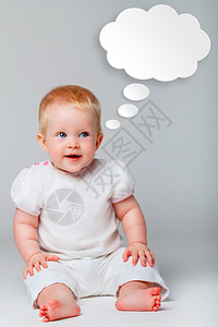 可爱的宝坐在灰色背景的地板上照片顶部的语音气泡图片