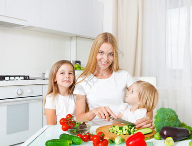 快乐的母亲和女儿在切菜在图片