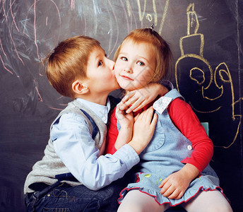 小可爱男孩在教室里在黑板上亲吻金发女孩图片