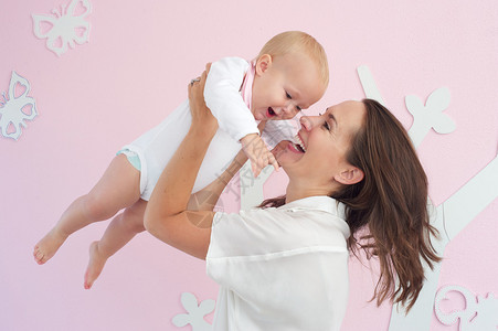 一个快乐的母亲和可爱的婴儿玩耍的近图片