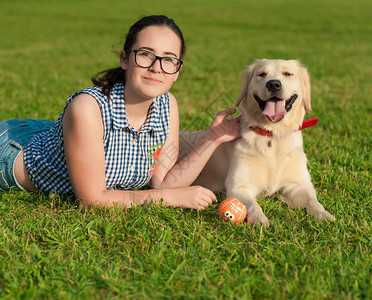 年轻美女的肖像躺着拥抱她的金色猎犬幸福和友谊图片