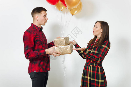 女人和男人拿着带有礼物和红色黄色气球的金色礼盒图片