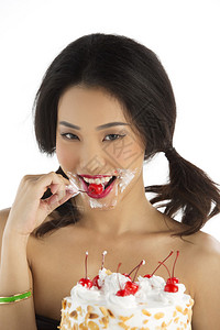 美丽的亚洲女孩吃樱桃脱樱桃的生日蛋图片
