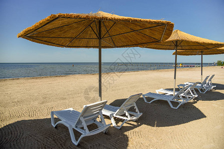 沙滩上的沙滩椅和遮阳伞高清图片