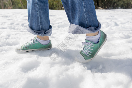 一个穿着街头鞋子和裤子的女人在雪图片